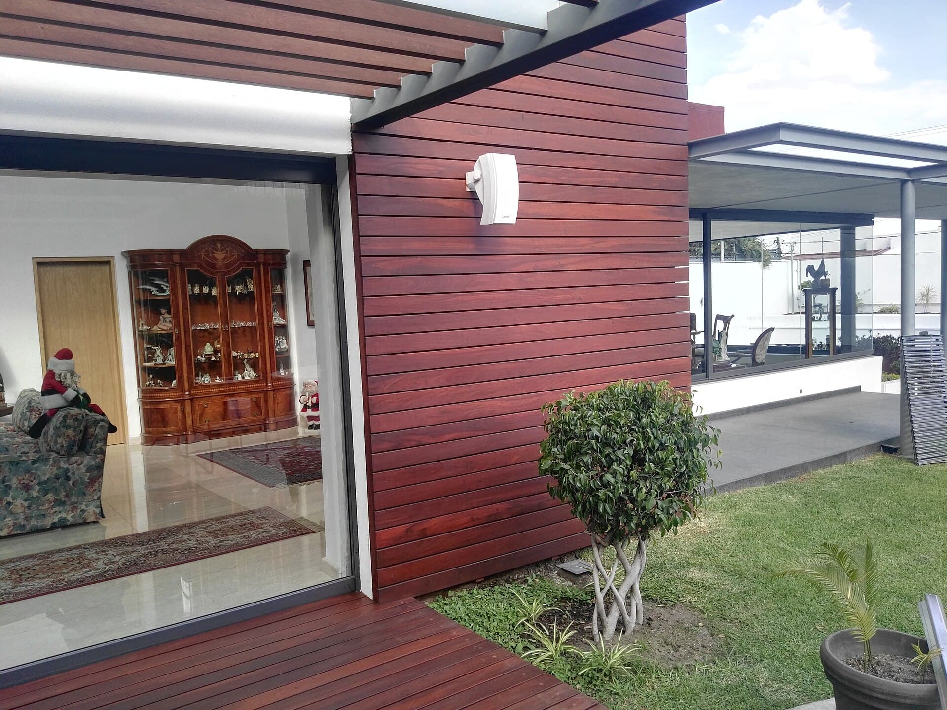 A house facade opening onto an outdoor timber deck, the junction a waterproofing problem when a room sits below.